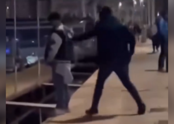 man gooit wildplassende migrant het water in